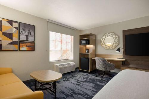 a hotel room with a bed and a desk and a television at La Quinta by Wyndham Austin Southwest in Austin