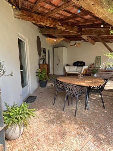 d'une terrasse avec une table et des chaises en bois. dans l'établissement Charmante petite maison avec terrasse et jardin, proche tram, à Castelnau-le-Lez