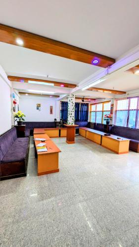 a large room with couches and tables in a building at Lamsang residency in Chug