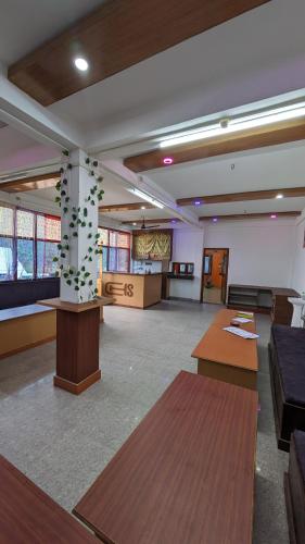 a large room with tables and a pillar in the middle at Lamsang residency in Chug