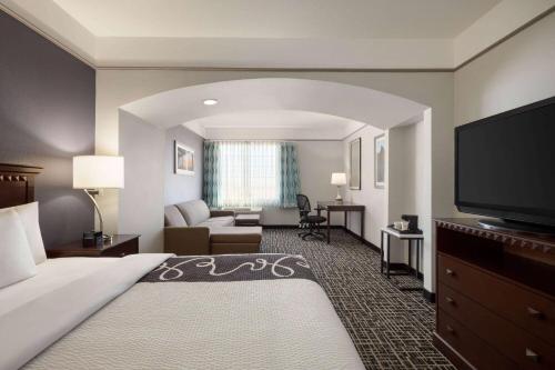 a hotel room with a bed and a flat screen tv at La Quinta by Wyndham Dumas in Dumas