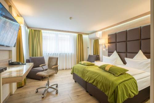 a hotel room with a bed and a desk at Best Western Plus Hotel Füssen in Füssen