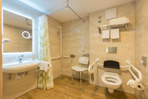 a bathroom with a toilet and a sink and a shower at Best Western Plus Hotel Füssen in Füssen