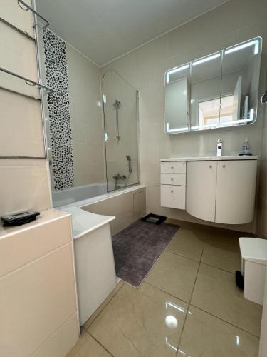 une salle de bain avec une baignoire, un lavabo et un miroir dans l'établissement Seaview Retreat 1BR with terrace, à Cannes