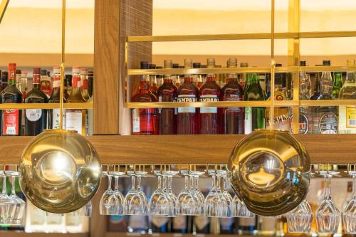 a bunch of wine glasses and bottles on a shelf at Best Western Plus Hotel Füssen in Füssen