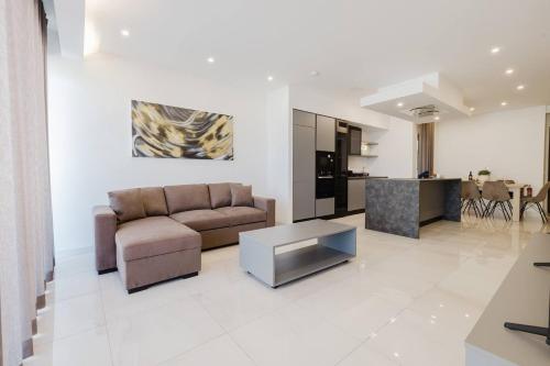 a living room with a couch and a table at Clover Leaf Apartment B 03 by Homely Malta! in St. Paul's Bay