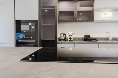 a kitchen with black and white cabinets and appliances at Clover Leaf Apartment B 03 by Homely Malta! in St. Paul's Bay