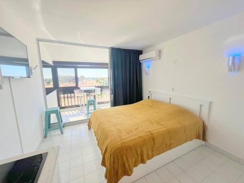 une chambre avec un lit et une grande fenêtre dans l'établissement Studio 301, PORT VENUS RESIDENCE au village naturiste, au Cap d'Agde