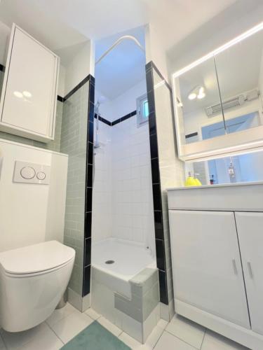 une salle de bain blanche avec toilettes et douche dans l'établissement Studio 301, PORT VENUS RESIDENCE au village naturiste, au Cap d'Agde