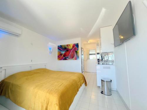 une petite chambre avec un lit et une cuisine dans l'établissement Studio 301, PORT VENUS RESIDENCE au village naturiste, au Cap d'Agde