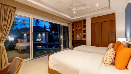 ein Schlafzimmer mit einem Bett und einem großen Fenster in der Unterkunft Velaya Blue Villa at Lipa Noi in Lipa Noi