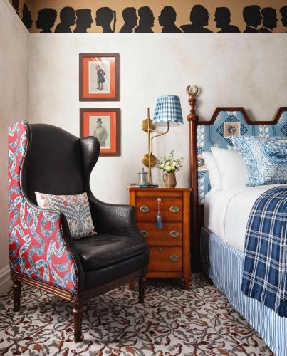 a bedroom with a bed and a black chair at Graduate by Hilton New Haven in New Haven