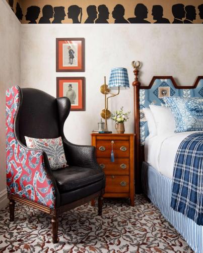 a bedroom with a bed and a black chair at Graduate by Hilton New Haven in New Haven