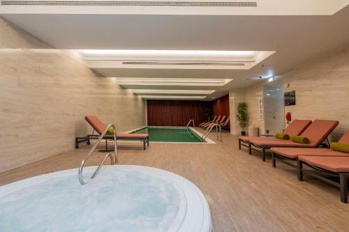 a hospital room with a tub and a pool at Cenica Porto Hotel, Curio Collection By Hilton in Porto
