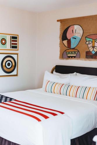 a bedroom with a white bed with a painting on the wall at Graduate by Hilton Tempe in Tempe