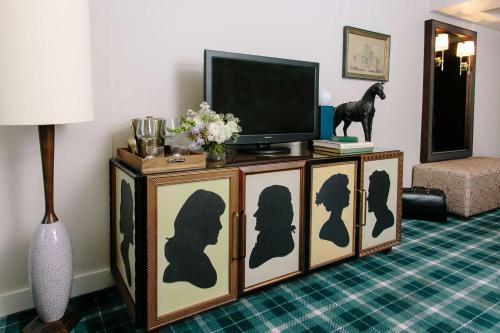 a living room with three cabinets with silhouettes on them at Graduate by Hilton Charlottesville in Charlottesville