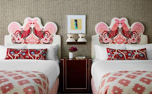 two beds with red and white pillows in a room at Graduate by Hilton Columbia SC in Columbia