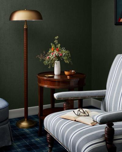 a living room with a chair and a table with a lamp at Graduate by Hilton Storrs in Storrs