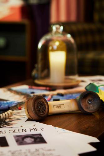 a wooden table with a candle and a bottle on it at Graduate by Hilton Bloomington in Bloomington