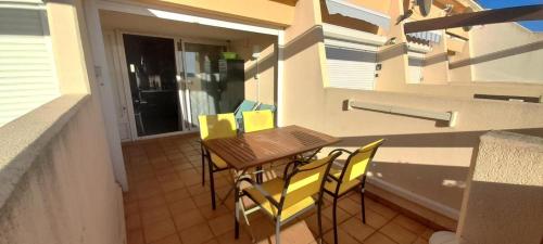 un balcon avec une table et des chaises sur un balcon dans l'établissement Appartement 357, PORT NATURE colline 3 au village naturiste, au Cap d'Agde