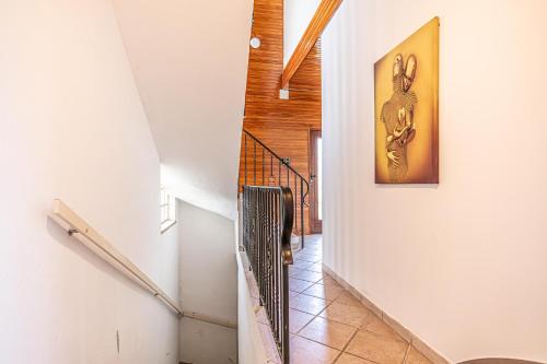 a hallway with white walls and a staircase with a picture on the wall at Cozy Central 11BR shared Stay with Garden Access & Terrace in Vienna