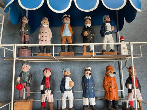 a group of toy figurines on a shelf at Pension KUROSHIOMARU in Setouchi