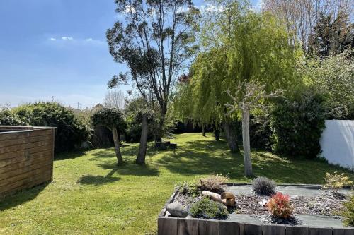 einen Garten mit Bäumen und Pflanzen im Hof in der Unterkunft La Cabane Rouge - Wifi - Parking in Les Bussolleries