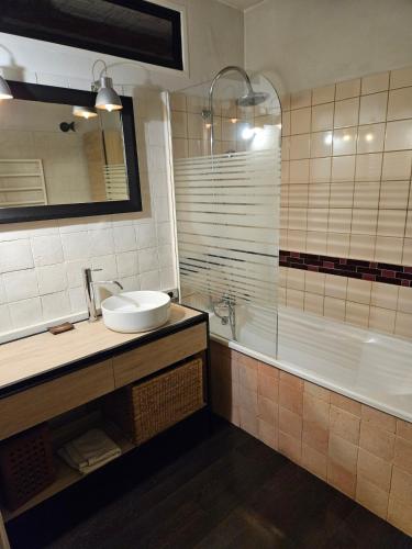 une salle de bain avec un lavabo et une baignoire dans l'établissement La longère de Fabien, à Saint-Jean-de-Braye