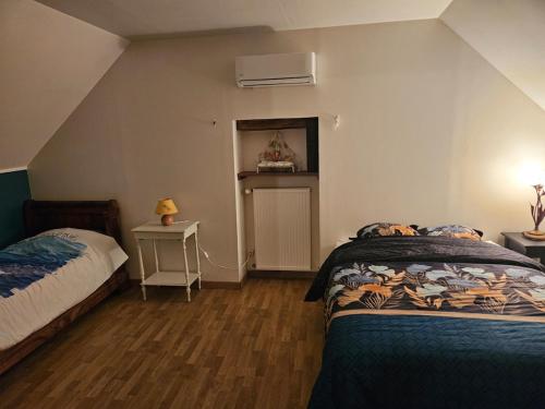 - une chambre avec 2 lits et une fenêtre avec un ventilateur dans l'établissement La longère de Fabien, à Saint-Jean-de-Braye