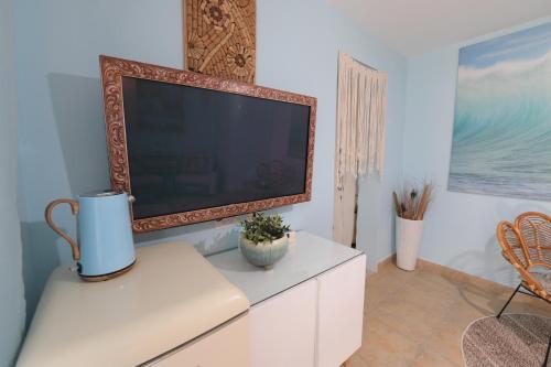 a flat screen tv sitting on top of a white cabinet at viktoryadream in Eilat