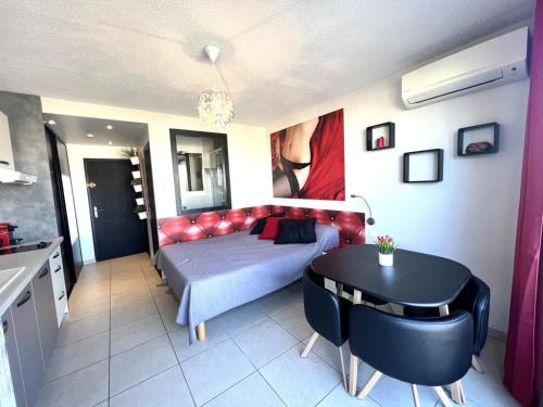 une chambre avec un lit et une table dedans dans l'établissement Studio 17C, HELIOPOLIS C au village naturiste, au Cap d'Agde