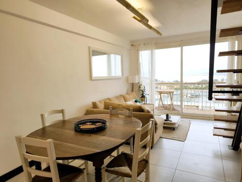 un salon avec une table et un canapé dans l'établissement Cocon vue mer sur Presqu'île, à Hyères