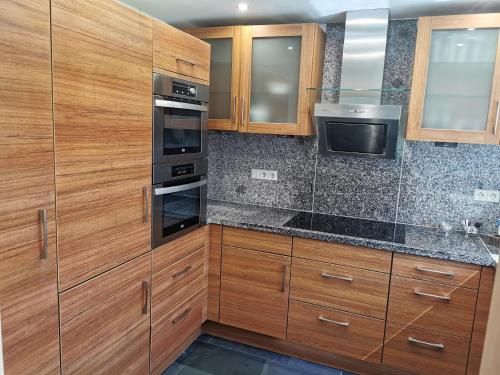 a kitchen with wooden cabinets and stainless steel appliances at Hotel Garni Jägerhof in Sigmaringen
