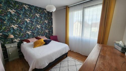 een slaapkamer met een bed met een bloemenmuur bij Maison proche centre ville et circuit avec jardin in Le Mans