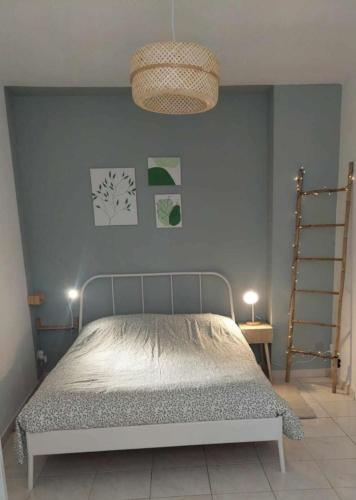 une chambre avec un lit et un mur bleu dans l'établissement A l'aube des bains, à Lamalou-les-Bains