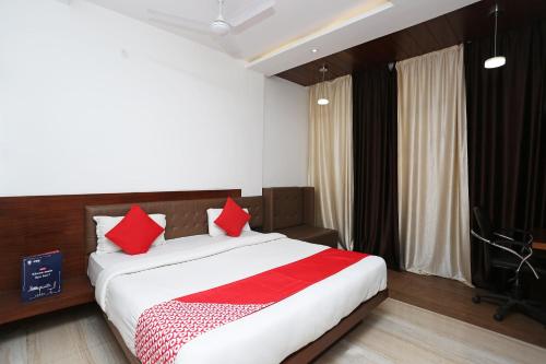 a bedroom with a large bed with red pillows at Collection O Sun Park in Bhopal