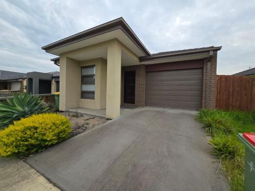 a house with a garage in front of it at Serenity Home 7 by Hiverooms in Pakenham
