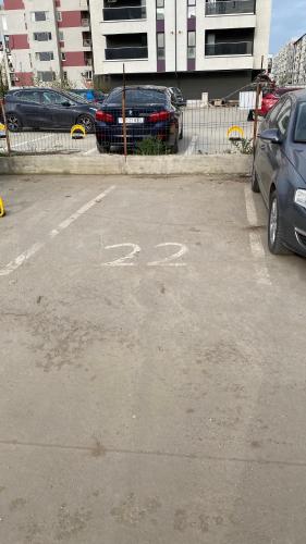 a parking lot with cars parked next to a fence at Apartament modern -with Free Parking in Chiajna