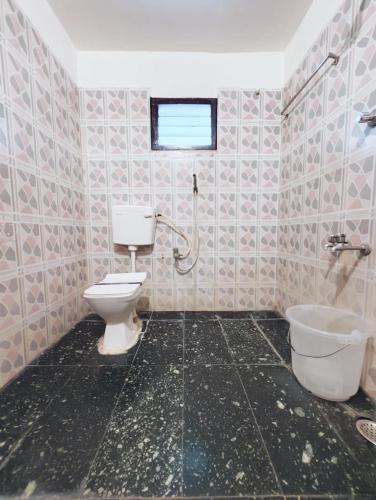 a bathroom with a toilet and a sink at Hare Rama Hare Krishna - EESHA Hotel in Rāmeswaram