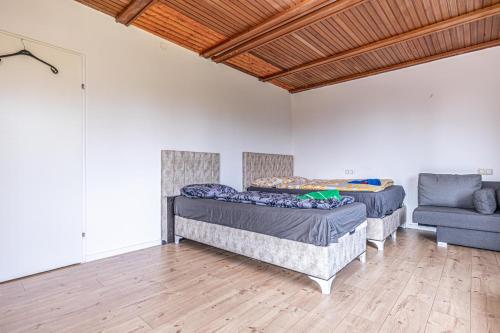two beds in a room with a couch and a chair at Cozy Central 11BR shared Stay with Garden Access & Terrace in Vienna