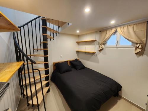 a bedroom with a bed and a spiral staircase at L'Essentiel in Savigny-sur-Orge