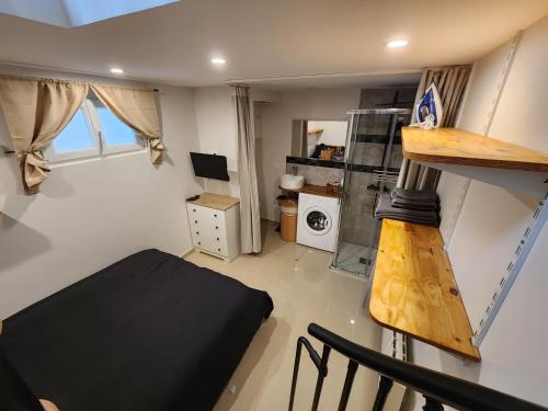 Cette petite chambre comprend un lit et une cuisine. dans l'établissement L'Essentiel, à Savigny-sur-Orge