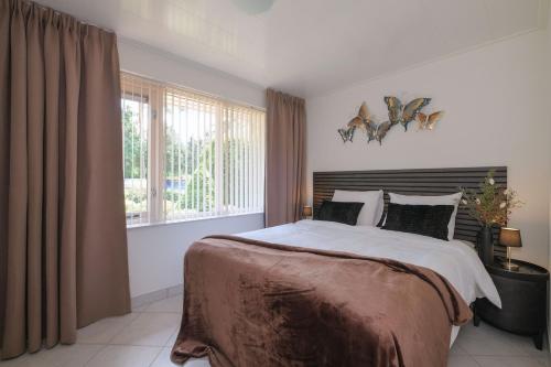a bedroom with a large bed and a window at Heidehuysje in Holten