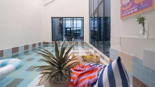 a pool with a plant in the middle of a room at Le Pavilion Pool Villa in Pohang