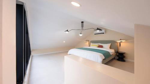 a white bedroom with a bed and a tv at Le Pavilion Pool Villa in Pohang