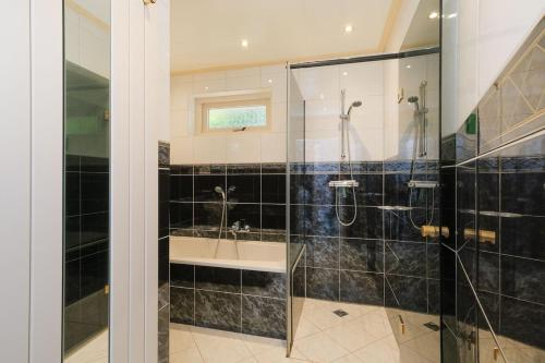 a bathroom with a shower with a glass door at Heidehuysje in Holten