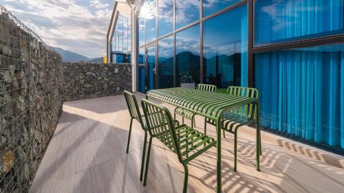 a green table and chairs on a balcony with mountains at Le Pavilion Pool Villa in Pohang