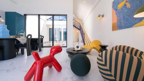 a living room with colorful chairs and a table at Le Pavilion Pool Villa in Pohang