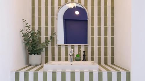 a bathroom sink with a mirror and a potted plant at Le Pavilion Pool Villa in Pohang