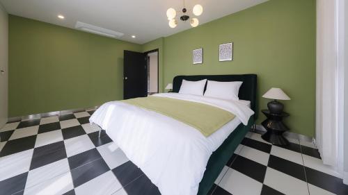 a green bedroom with a bed and a checkered floor at Le Pavilion Pool Villa in Pohang